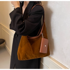 Detail of caramel brown suede hobo bag with matching side pouch and smooth strap