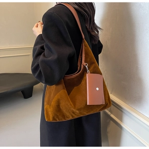Detail of dark brown suede tote bag with leather pouch on black wool coat model