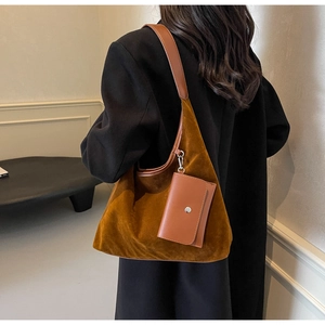 Detail of dark brown faux suede crescent shoulder bag with matching mini pouch charm