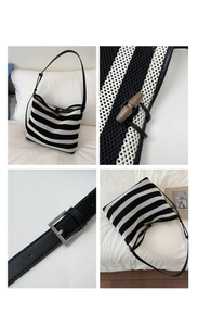 Detail of woven striped tote bag featuring wooden horn button and adjustable leather strap