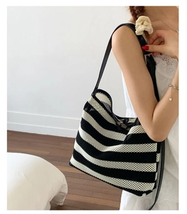 Détail du sac cabas en maille rayée noir et blanc avec bretelles en cuir noir