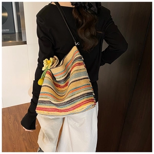 Dettaglio della trama della borsa hobo intrecciata a righe colorate con ciondolo a fiore
