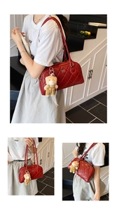 Detail of red quilted bowling bag featuring a metallic zipper and a cute brown bear charm