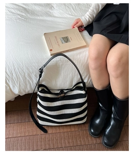 Détail du sac cabas tissé à rayures noires et blanches avec bandoulière en cuir réglable