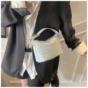 Detail of light mint green woven leather handbag with gold twist lock and crossbody D-rings