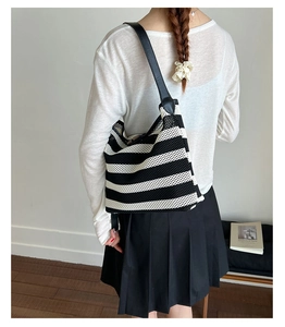Détail du sac cabas tissé à rayures noires et blanches avec bandoulière large en cuir