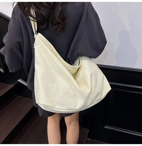 Detalle de bolso tote de lona blanco crema con correa ancha y forma de media luna