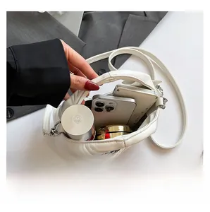 Internal capacity of the white quilted mini bag showing space for phones and cosmetics