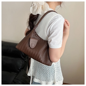 Detail of dark brown woven shoulder bag showing handcrafted faux leather texture