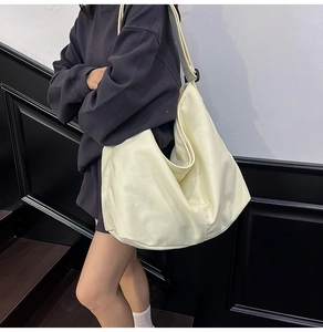 Vista detallada de un gran bolso tote de lona beige en modelo para estilo diario