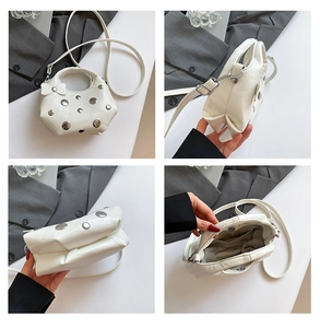 Detail view of white rivet cloud bag with leather bow and polished silver hardware accents