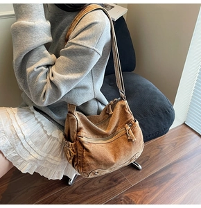 Detailed view of brown canvas hobo bag with multiple zippers and retro casual design