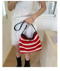 Détail du sac hobo en maille rayée rouge et blanc avec fines anses en cuir noir
