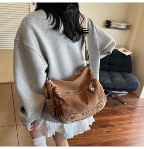 Detail of vintage brown canvas crossbody bag showing multiple pockets and distressed texture