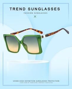 Detail of emerald green oversized square sunglasses with tortoiseshell temples and UV400 lenses