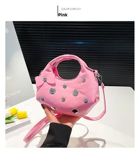 Pink crescent moon bag with silver studs and a cute bow charm in a lifestyle setting