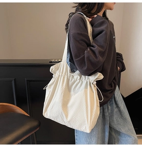 Dettaglio della borsa tote in nylon beige con tessuto strutturato e coulisse