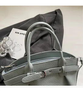 Close-up of light blue lychee pattern handbag with silver hardware and dual handles