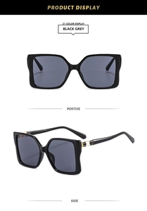 Detail of black grey oversized square sunglasses with gold honeycomb temple accents