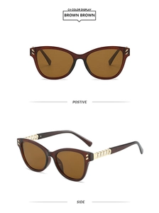 Detail view of cat eye sunglasses featuring gold metal chain temples and brown lenses