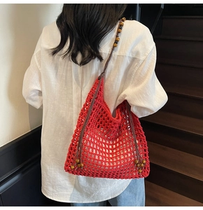 Detail of red hollow straw tote with wooden bead straps for summer beach vacation