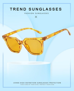 Detail view of square tortoiseshell sunglasses with yellow tinted lenses and UV400 protection