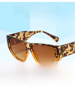 Detail of tortoiseshell square sunglasses with brown gradient lenses on blue background