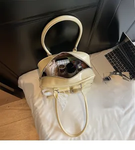 Top view of spacious cream patent leather bowling bag with lace bow showing inner storage