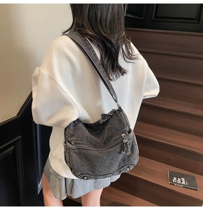 Dettaglio della borsa a tracolla in denim lavato con tasche multiple e spallina regolabile
