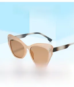 Detail of nude cat-eye sunglasses with amber lenses and gradient grey temples