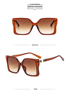 Detail of stylish oversized square amber frame sunglasses with brown gradient lenses