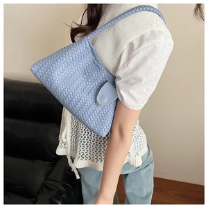 Close-up of light blue woven tote bag showing detailed texture and buckle closure