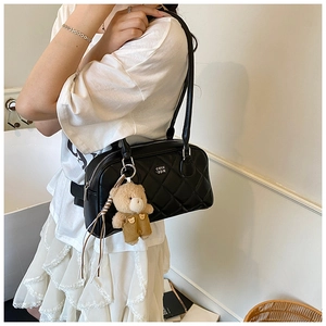 Détail du sac cabas matelassé noir avec un porte-clé ours en peluche et lettrage COIH '2DN