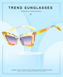 Detail of cat eye sunglasses with orange wave frame and gradient purple UV400 lenses