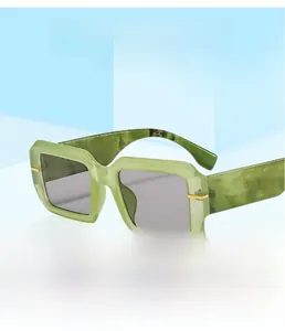 Detail of green marble texture square sunglasses with grey lenses and gold metal accents