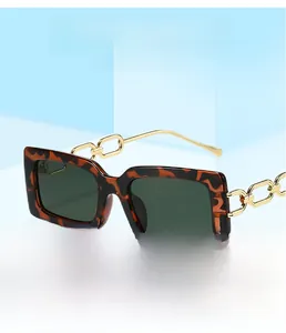 Dettaglio occhiali da sole squadrati tartarugati con eleganti stanghette a catena dorata