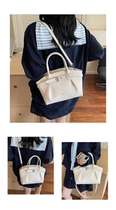 Detailed view of the creamy white bucket bag with pebble leather texture and silver buckle