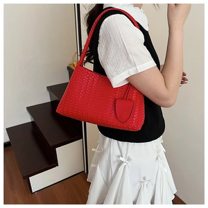 Close-up of red woven hobo bag with matching small coin purse and textured strap