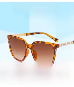 Close-up of tortoise shell square sunglasses featuring luxury pearl temple decorations