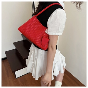 Close-up of red woven shoulder bag showing premium Intrecciato craft and mini coin purse