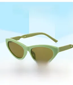 Detail view of mint green matte cat-eye sunglasses with brown UV protective lenses