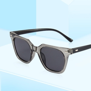 Modern square retro sunglasses with grey transparent frame and dark lenses on blue background