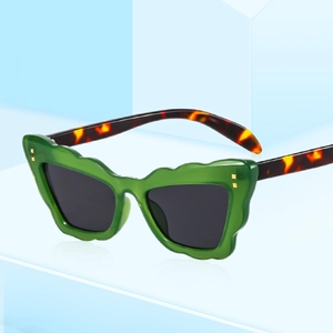Fashionable cat-eye sunglasses with green wavy frames and tortoiseshell temples