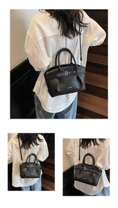 Detail of black pebble leather bucket bag featuring metal buckle and adjustable shoulder strap