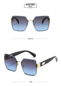 Detail view of square rimless sunglasses with gradient blue-grey lenses and gold metal frames