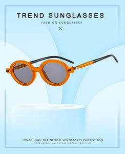 Détail de lunettes rétro oranges sur support bleu montrant la protection UV400 et les branches