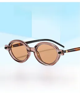 Détail de lunettes de soleil ovales marron translucide avec branches écaillées au style rétro