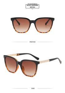 Detail of square cat eye sunglasses with gold wave temples and pearl accents