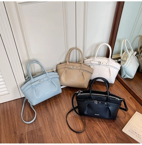 Detail view of stylish pleated leather handbags in light blue, khaki, beige and black colors
