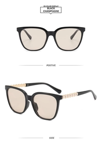 Detail of square black sunglasses with champagne lenses and pearl-embellished temples